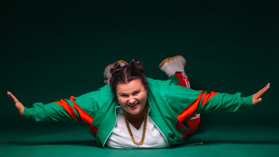 A woman with arms splayed out smiling