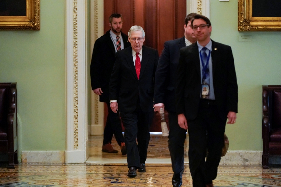 Mitch McConnell Men in suits walk down a hallway