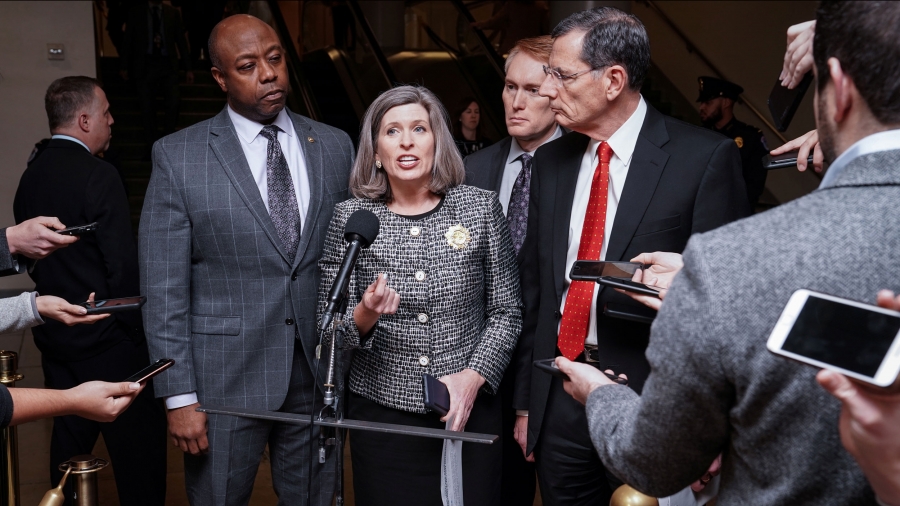 Joni Ernst A woman speaks surrounded by men