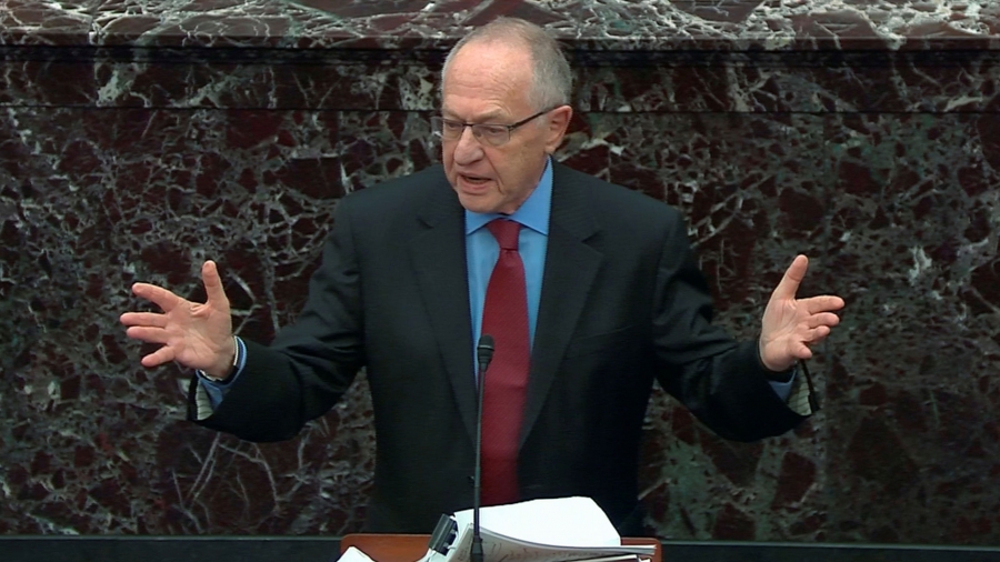 Alan Dershowitz A man speaks at a podium with his hands outstretched