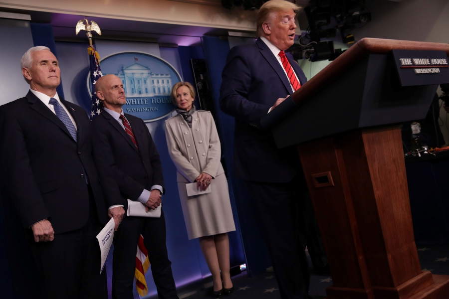 President Donald Trump addresses the coronavirus response daily briefing at the White House President Trump stands at a White House podium with officials behind him.