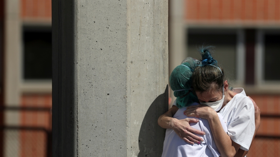 Medical workers hug each other outside the emergency rooms at Severo Ochoa Hospital during the coronavirus disease (COVID-19) outbreak in Leganes, Spain, March 26, 2020. Two nurses hug each other
