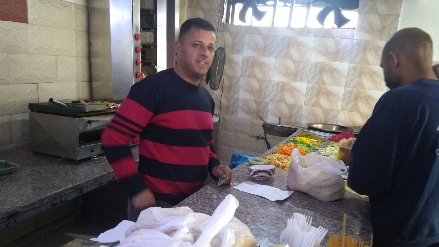 Falafel at the Fence café in Baka al-Gharbiyeh. Two men stand at the counter preparing falafel at the Fence café in Baka al-Gharbiyeh.