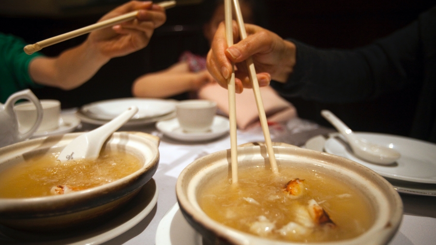 A family eats soup at Vancouver's Grand Honor Chinese restaurant in Vancouver, British Columbia, July 1, 2012. Two people eat with chopsticks at a restaurant