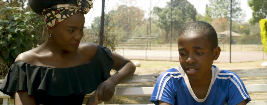 A woman looks at a boy in a film screen grab