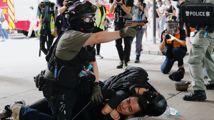Riot police use water cannon to disperse anti-national security law protesters during a march at the anniversary of Hong Kong's handover to China from Britain in Hong Kong, China, July 1, 2019. Riot police use water cannon to disperse protesters and one officer presses down on a protester