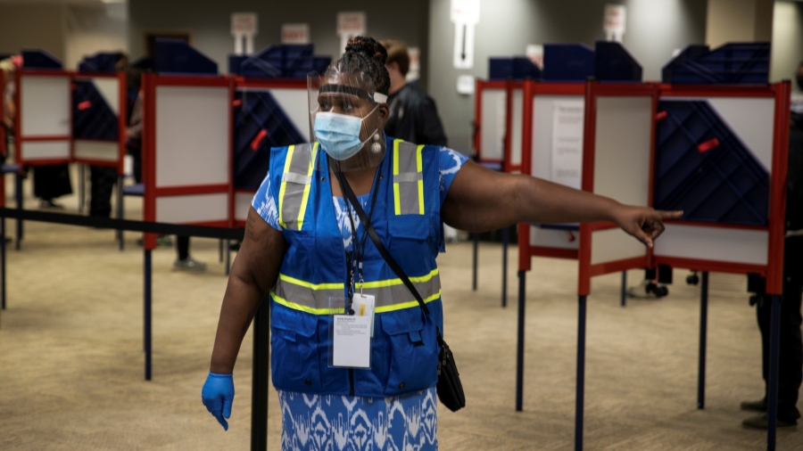 A poll worker directs voters to cast their ballots for the upcoming presidential election as early voting begins in Cincinnati, Ohio, Oct. 6, 2020.