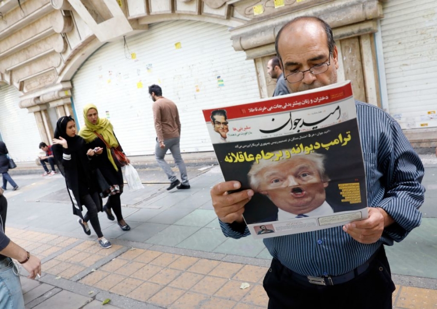 Iranian media outlets have been particularly harsh on the president, with this headline calling him ‘Crazy Trump.’ A man reads an Iranian newspaper with a sensational photo of U.S. President Trump on the cover.
