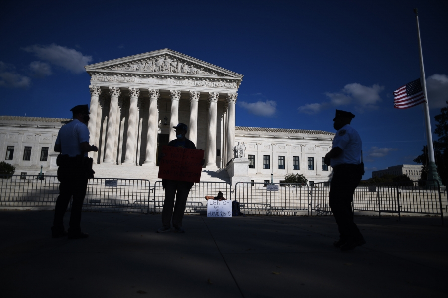 Police officers talk to one of two demonstrators who gather outside the Supreme Court in Washington, D.C., October 15, 2020, to protest the nomination of Judge Amy Coney Barrett. Police officers talk to one of two demonstrators who gather outside the Supreme Court in Washington, D.C., October 15, 2020, to protest the nomination of Justice Amy Coney Barrett.