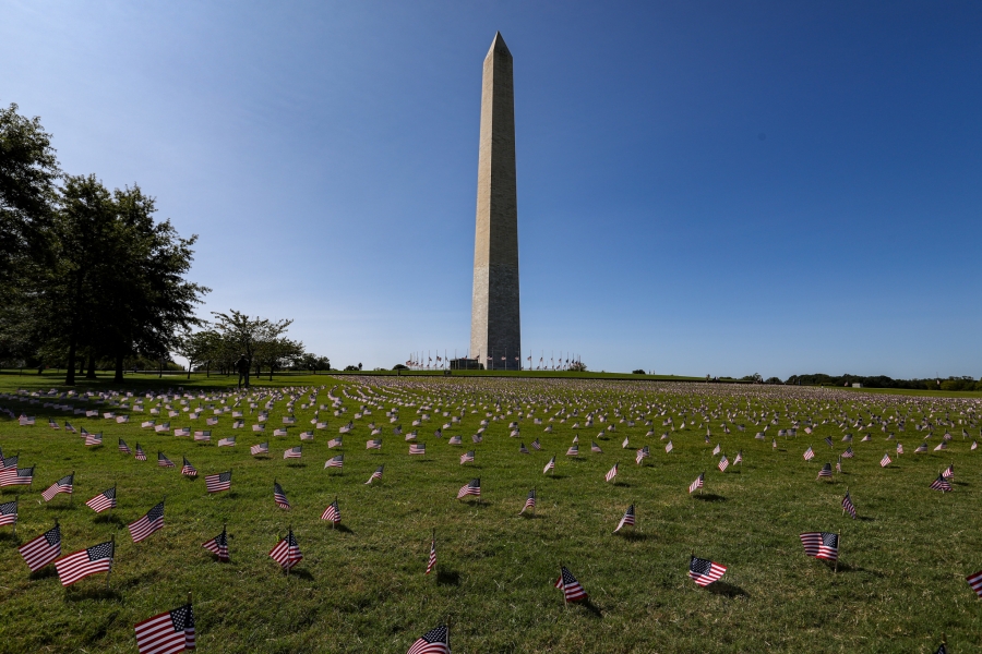COVID Memorial Project placed 20,000 U.S. flags on the National Mall when the U.S. COVID-19 death toll passed 200,000. The Washington Monument surrounded by small flags in the ground around it, in memory of people who died from the coronavirus pandemic.