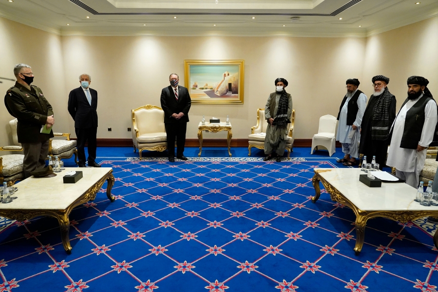 Former U.S. Secretary of State Mike Pompeo and other U.S. officials meet with senior Taliban leaders in Doha, Qatar, November 2020. A group of men stand apart in a meeting room, masked and socially distanced because of the coronavirus pandemic.