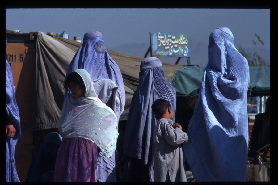Women were required to be fully veiled in public when the Taliban ruled Afghanistan. Kabul, 1996. A candid photo of three woman who are fully veiled.