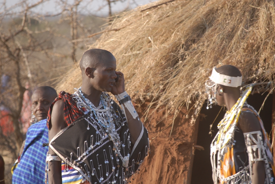 A Maasai man talks on his phone during a community gathering. A Maasai man talks on his phone during a community gathering.