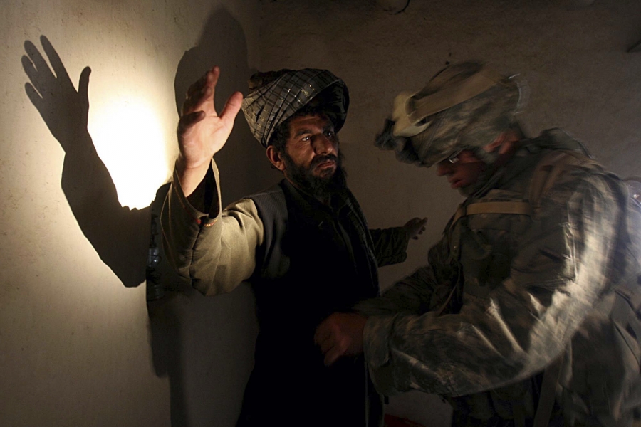 A US soldier of B company, 4th Infantry Regiment frisks an Afghan man in his house during a search operation in Sinan village in Zabul province, southeastern Afghanistan, on April 2, 2007. A US soldier of B company, 4th Infantry Regiment frisks an Afghan man in his house during a search operation in Sinan village in Zabul province, southeastern Afghanistan, on April 2, 2007.