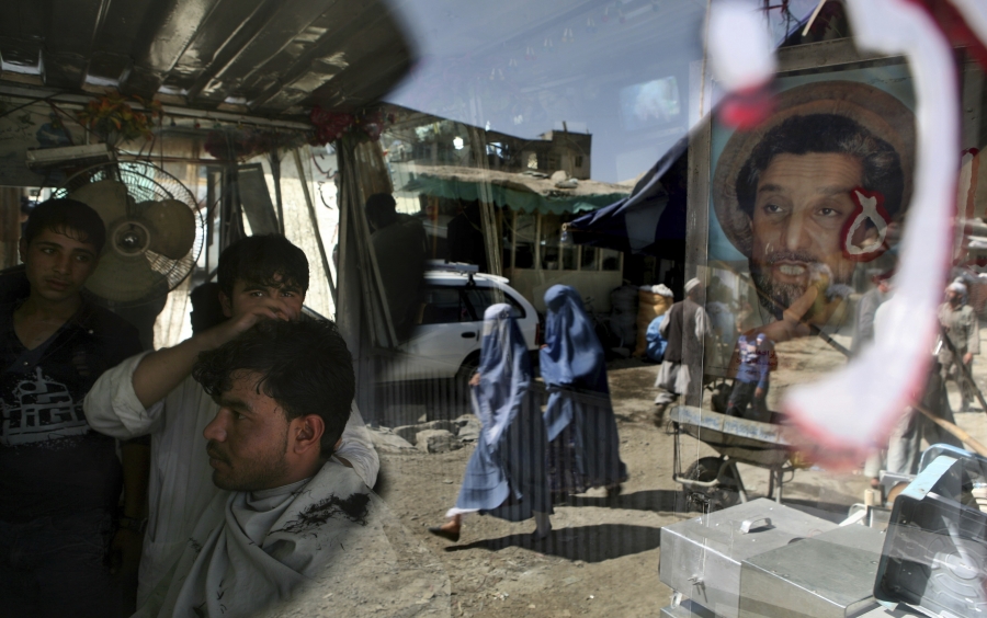 An Afghan barber works on a customer in his shop as a portrait of Afghanistan national hero Ahmad Shah Massoud adorns its door in Kabul, Afghanistan, on Sept. 29, 2009. An Afghan barber works on a customer in his shop as a portrait of Afghanistan national hero Ahmad Shah Massoud adorns its door in Kabul, Afghanistan, on Sept. 29, 2009.