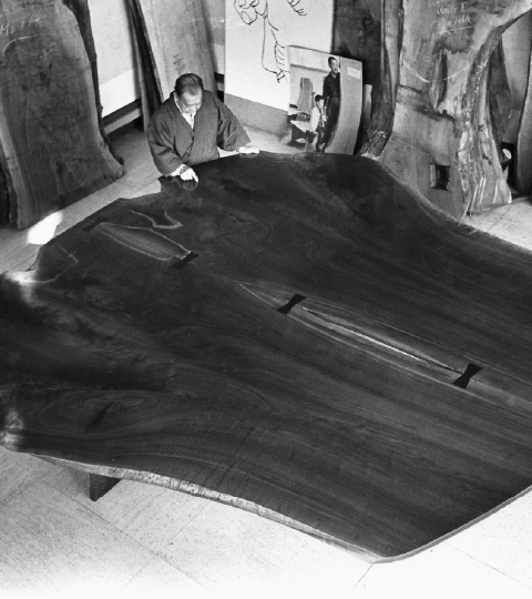 George Nakashima examines his third “peace altar.” It’s a table constructed with two giant cuts of black walnut attached together with butterfly joints. George Nakashima examines his third “peace altar.” It’s a table constructed with two giant cuts of black walnut attached together with butterfly joints.