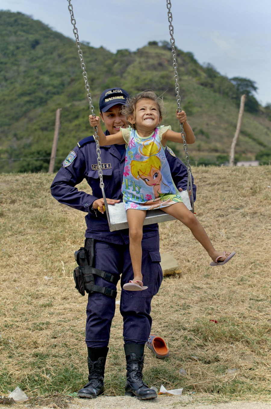 Honduran police officer Julisa Carias gives Jireh López, 4, a push on a swing in Chamelecón, a neighborhood in San Pedro Sula. Honduran police officer Julisa Carias gives Jireh López, 4, a push on a swing in Chamelecón, a neighborhood in San Pedro Sula.