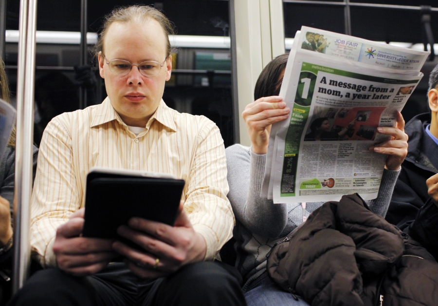 A commuter reads on a Kindle e-reader while riding the subway in Cambridge, Mass. Neuroscience says the way his brain treats reading on the Kindle is different than the way the brain processes the newspaper next to him. A commuter reads on a Kindle e-reader while riding the subway in Cambridge, Mass. Neuroscience says the way his brain treats reading on the Kindle is different than the way the brain processes the newspaper next to him.