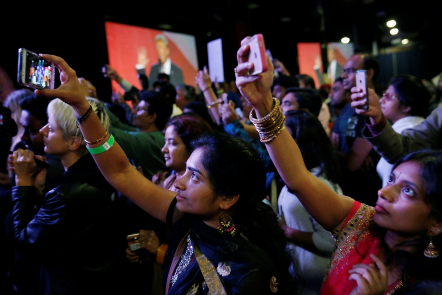 People in crowd hold up cellphones People in crowd hold up cellphones