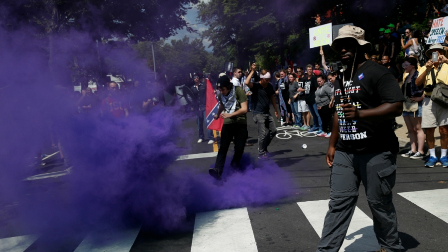 A smoke bomb is thrown at a group of counter-protesters during a clash against members of white nationalist protesters in Charlottesville, Virginia, U.S., August 12, 2017.