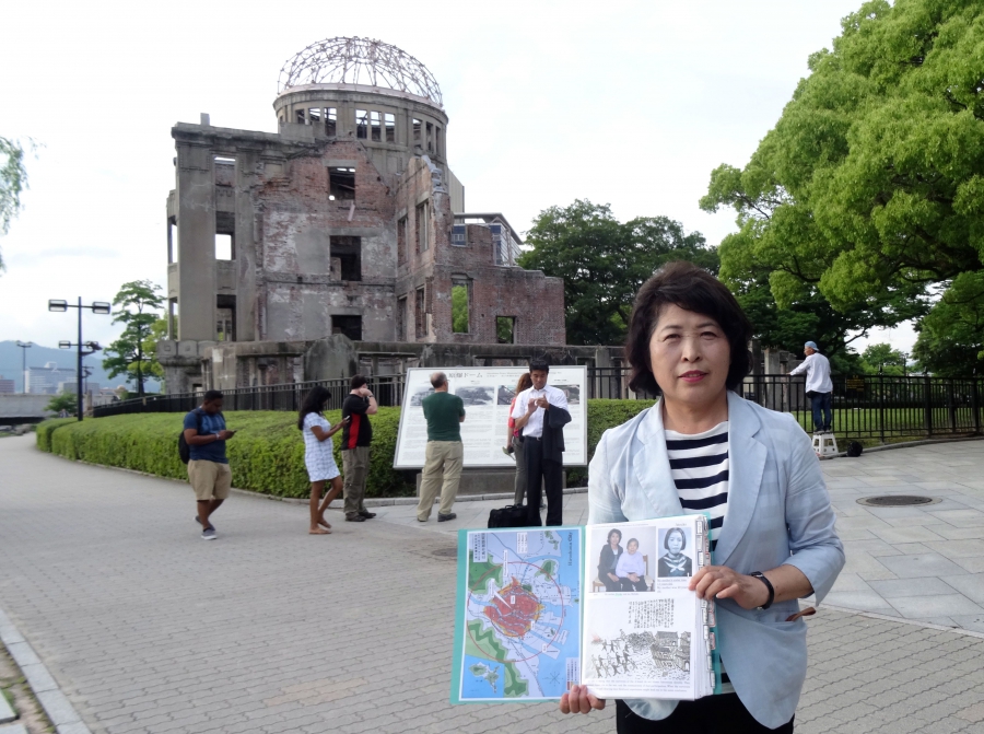 Hiroshima guide and 'memory keeper' Michiko Yamaoka holds a folder containing photos of her mother, who survived the blast, and her aunt, who died. Hiroshima guide and 'memory keeper' Michiko Yamaoka holds a folder containing photos of her mother, who survived the blast, and her aunt, who died.