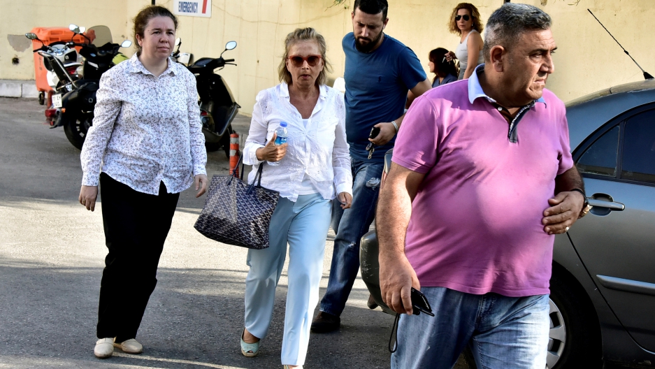 REUTERS/Kenan Gurbuz Turkish journalist Nazli Ilicak (C), also a well-known commentator and former parliamentarian, is escorted by a police officer (R) and her relatives (L and rear) after being detained and brought to a hospital for a medical check in Bodrum, Turkey, July 26