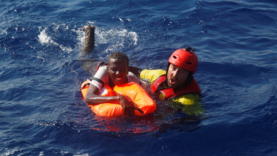 A member of the Spanish NGO Proactiva rescues a Somali migrant that fell from an overcrowded dinghy, during a rescue operation off the Libyan coast in Mediterranean Sea August 28 , 2016. REUTERS/Giorgos Moutafis