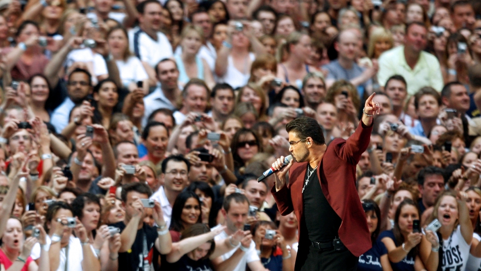 George Michael with a microphone in front of a crowd