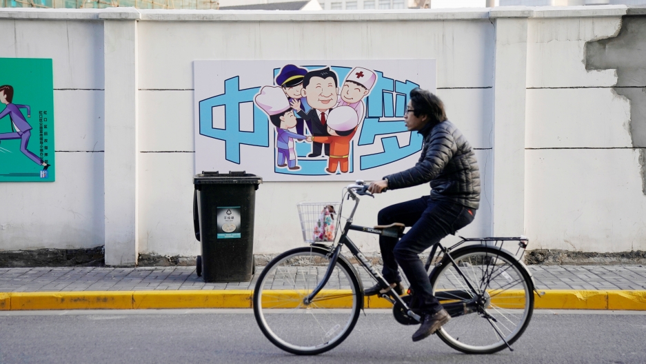 A cartoon depicting Chinese President Xi Jinping with the Chinese characters reading "Dream of China" is seen on a street in Shanghai. A cartoon depicting Chinese President Xi Jinping with the Chinese characters reading "Dream of China" is seen in the background as a bicyclist rides past.