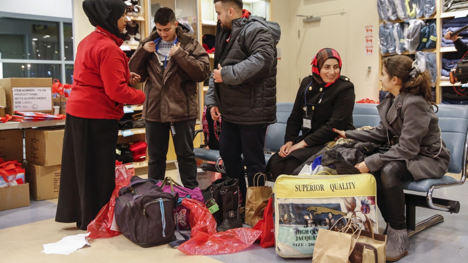 Syrian refugees receive winter clothing as they arrive at the Pearson Toronto International Airport in Mississauga, Ontario, December 18, 2015.