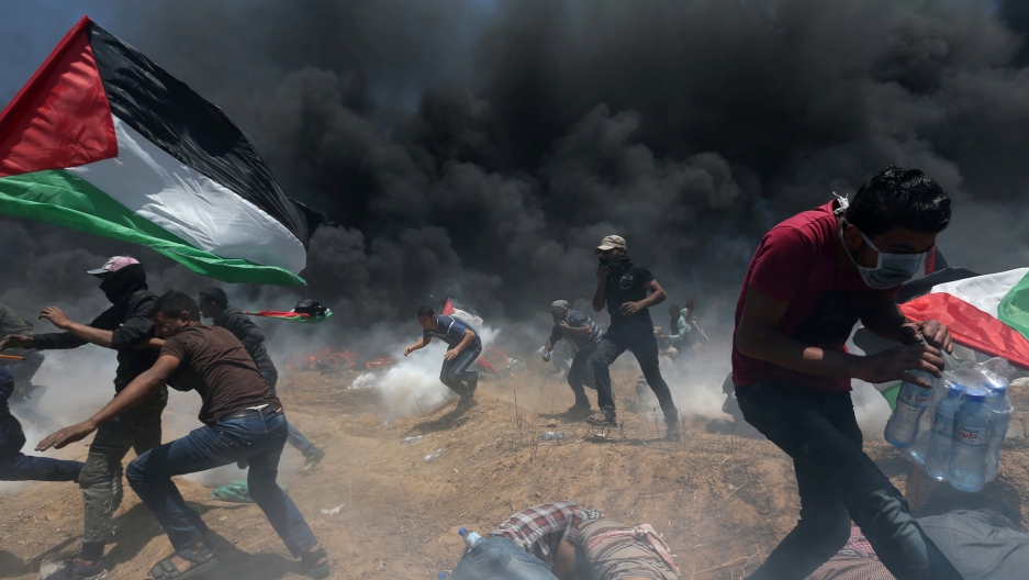 Palestinian demonstrators run for cover from Israeli fire and tear gas during a protest against US embassy move to Jerusalem, May 14, 2018. Palestinian demonstrators run for cover from Israeli fire and tear gas during a protest against US embassy move to Jerusalem, May 14, 2018.