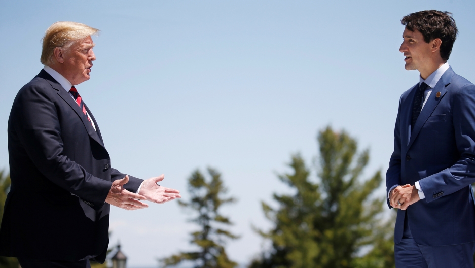 US President Donald Trump approaches Canada's Prime Minister Justin Trudeau as he arrives at the G7 Summit in Quebec, June 8, 2018. US President Donald Trump is seen left with his hands out reaching toward Canada's Prime Minister Justin Trudeau on the right of the frame.