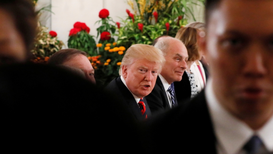 US President Donald Trump and members of his delegation attend lunch in Singapore ahead of a meeting with North Korean leader Kim Jong-un. US President Donald Trump is seated at a table along side members of his delegation in Singapore.
