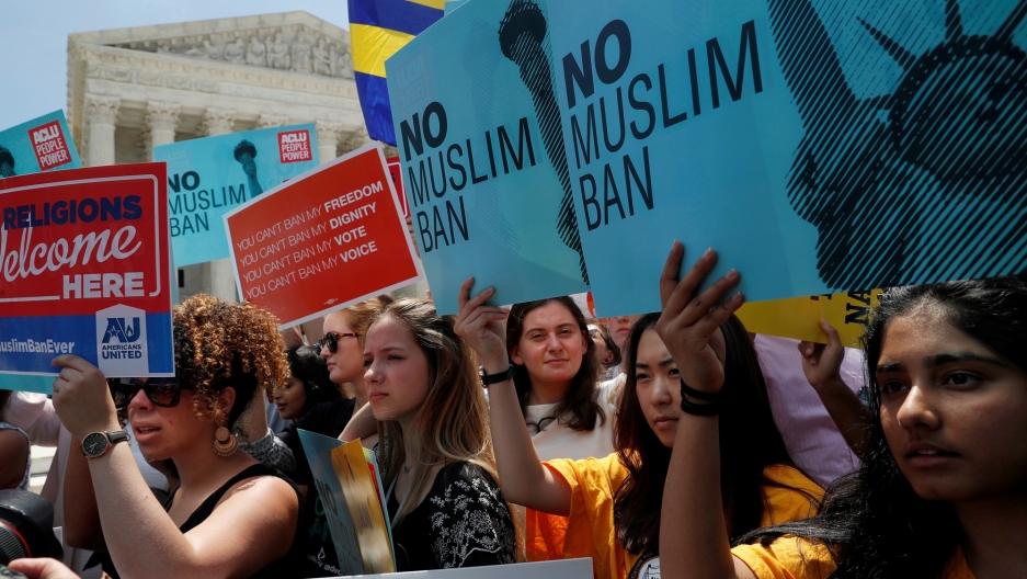 People protest outside of the US Supreme Court after the President Trump's travel ban was upheld by the Supreme Court in Washington, June 26, 2018. People protest outside of the US Supreme Court with placards that read, "No Muslim Ban."