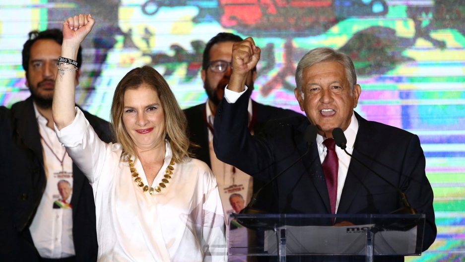 Andrés Manuel López Obrador with his wife Beatriz Gutierrez Muller and family as he addresses supporters after polls closed in the presidential election, in Mexico City, Mexico, July 1, 2018. Andrés Manuel López Obrador and his wife Beatriz Gutierrez Muller raise their clenched hands on a stage in Mexico City.