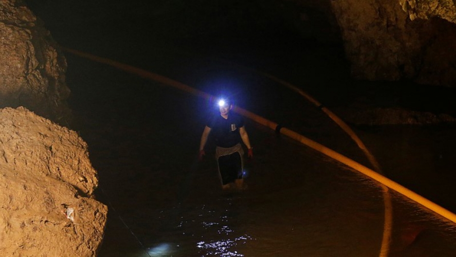 A diver walks in Tham Luang cave complex during the search for members of an under-16 soccer team and their coach, in the northern province of Chiang Rai, Thailand. A diver walks in Tham Luang cave complex wearing waders and a headlamp.