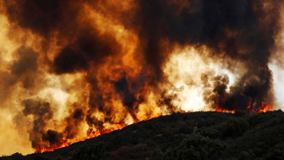 Wind-driven flames roll over a hill toward homes during near Lakeport, California, August 2, 2018. Wind-driven flames roll over a forested hill toward homes during near Lakeport, California, August 2, 2018.