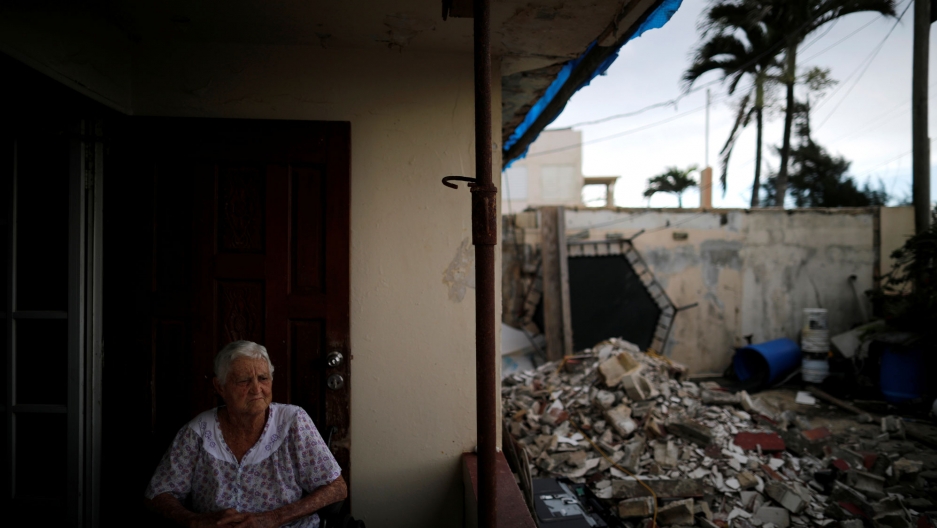 Lucila Cabrera, 86, sits at the porch of her damaged house by Hurricane Maria, a year after the storm devastated Puerto Rico, near Barceloneta, Sept. 18, 2018. Lucila Cabrera is shown sitting on her porch with damaged buildings visible nearby.