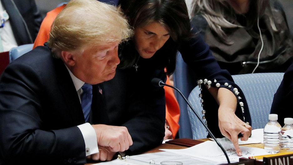 US Ambassador to the United Nations Nikki Haley points at her handwritten notes for President Donald Trump as he chairs a UN Security Council meeting at UN headquarters in New York, Sept. 26, 2018. US Ambassador to the United Nations Nikki Haley leans over a seated President Donald Trump points at her handwritten notes.