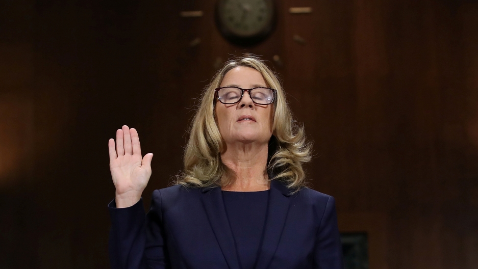 Dr. Christine Blasey Ford is sworn in before testifying the Senate Judiciary Committee in Washington, DC, Sept. 27, 2018. Dr. Christine Blasey Ford is shown with her right hand raised and eyes closed.