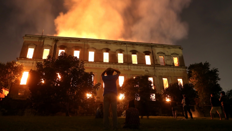 People watch as a fire burns at the National Museum of Brazil