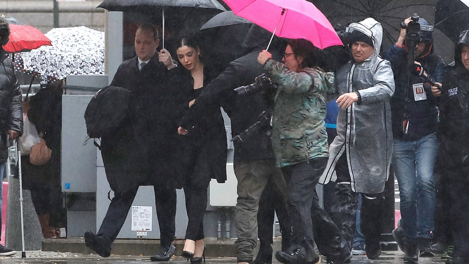 Emma Coronel Aispuro, the wife of Joaquín Guzmán, the Mexican drug lord known as "El Chapo," arrives at the Brooklyn Federal Courthouse ahead of the start of the trial of Guzmán in New York, Nov. 13, 2018. Emma Coronel Aispur is shown surrounded by several photographers walking while underneath umbrellas.