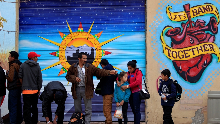 Central American migrants queue for food as they wait for transportation to emergency shelters in El Paso