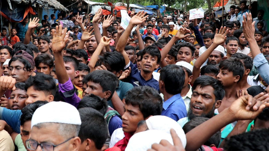 a large group of Rohingya refugees shout slogans