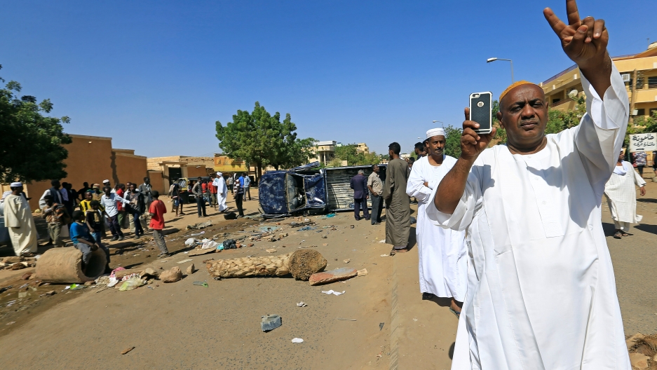 A Sudanese man makes a peace sign with his hands