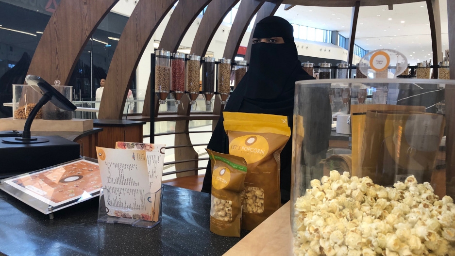 Twenty-five-year-old Hessa sells popcorns at the Riyadh Park mall in Riyadh, Saudi Arabia. A woman wearing a black veil sells popcorn at a stand at a mall.