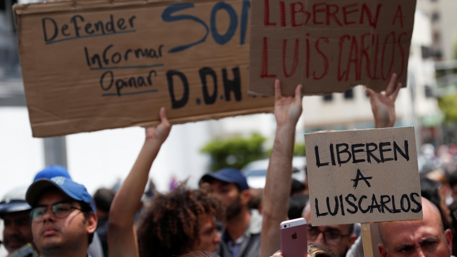 several people hold up signs made from cardboard