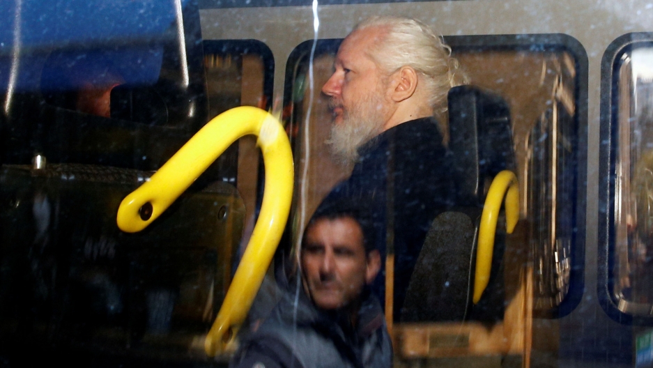 WikiLeaks founder Julian Assange is seen inside a police van, after his arrest, in London, Britain, April 11, 2019. WikiLeaks founder Julian Assange is seen in profile sitting inside a police van in a photo taken through glass that has a reflection of a man.