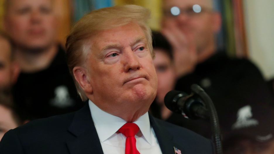 President Donald Trump is shown with his mouth closed looking off to his left.