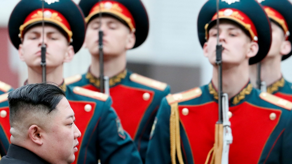 North Korean leader Kim Jong-un arrives at the railway station in the Russian far-eastern city of Vladivostok, April 24. A side profile photo of Kim Jong-un with Russia soldiers in dress uniforms in the background.